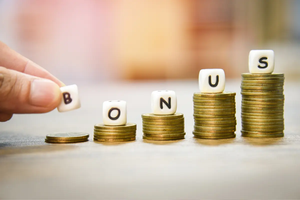 Pile di monete con dadi ortografia "BONUS"