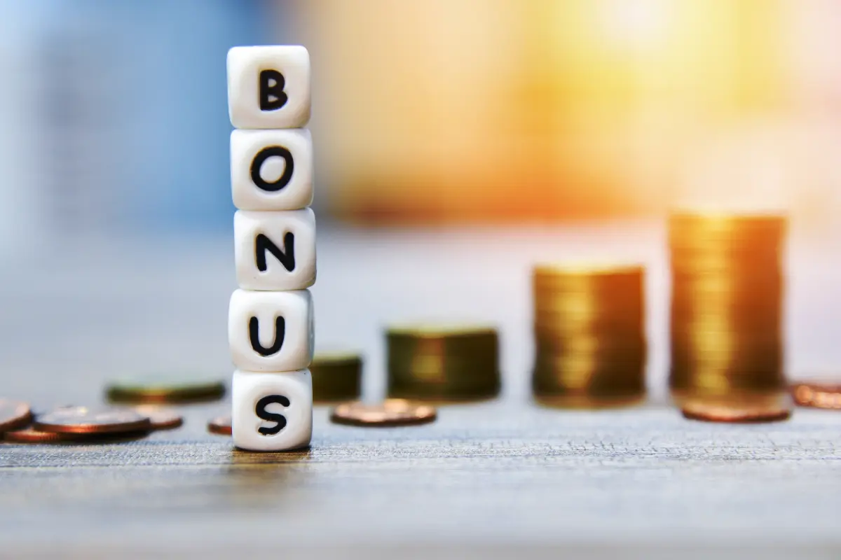 Bonus Natale rappresentato da cubi di lettere e pile di monete