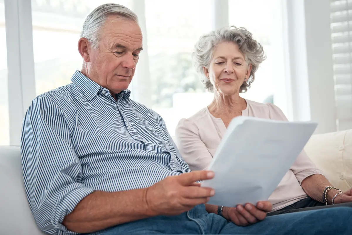Coppia di pensionati consulta il cedolino pensioni INPS gennaio 2025 sul divano